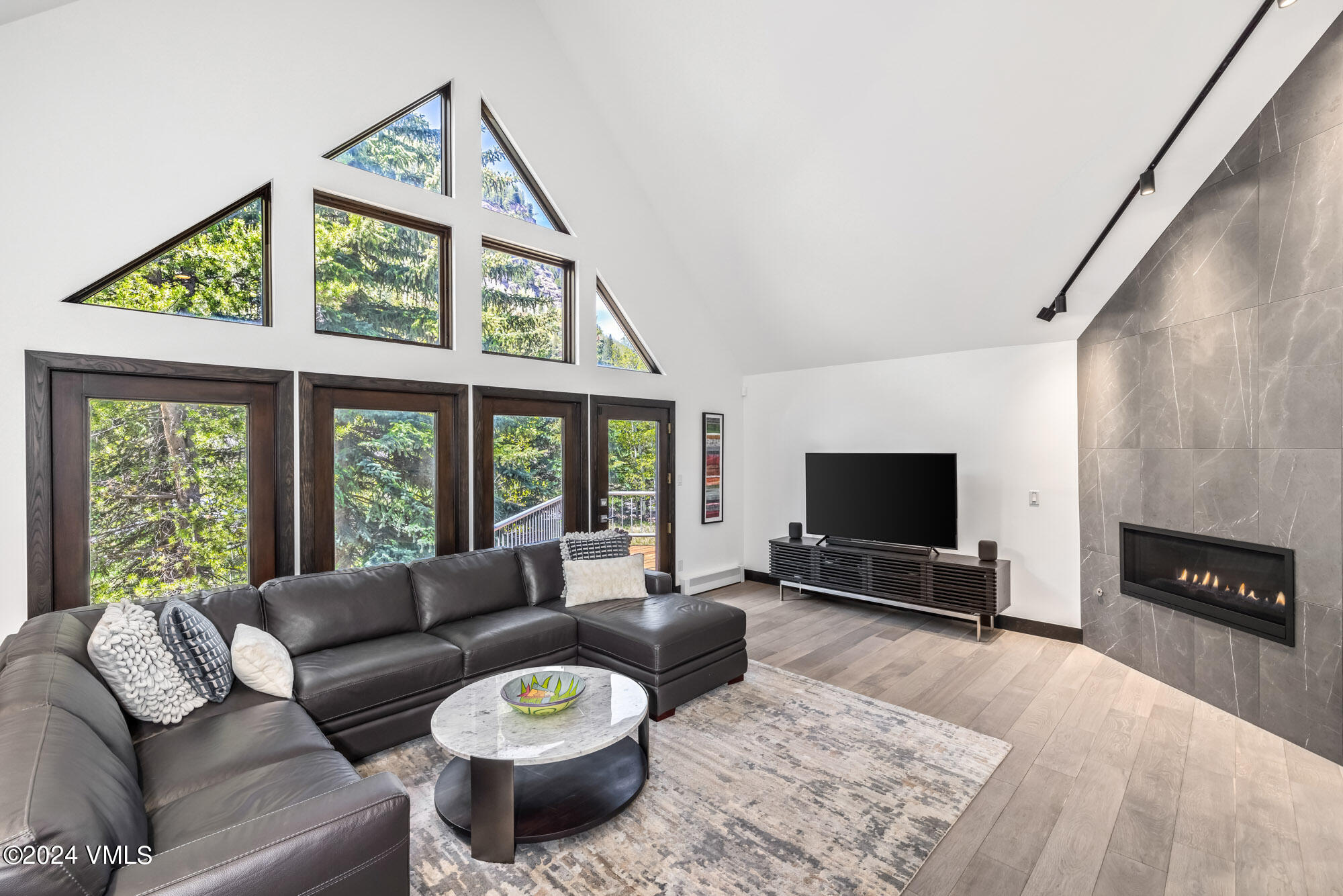 a living room with furniture a flat screen tv and a fireplace