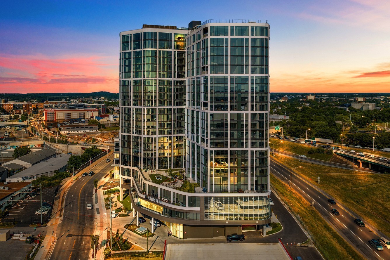 a view of a balcony with a floor to ceiling window next to a city view