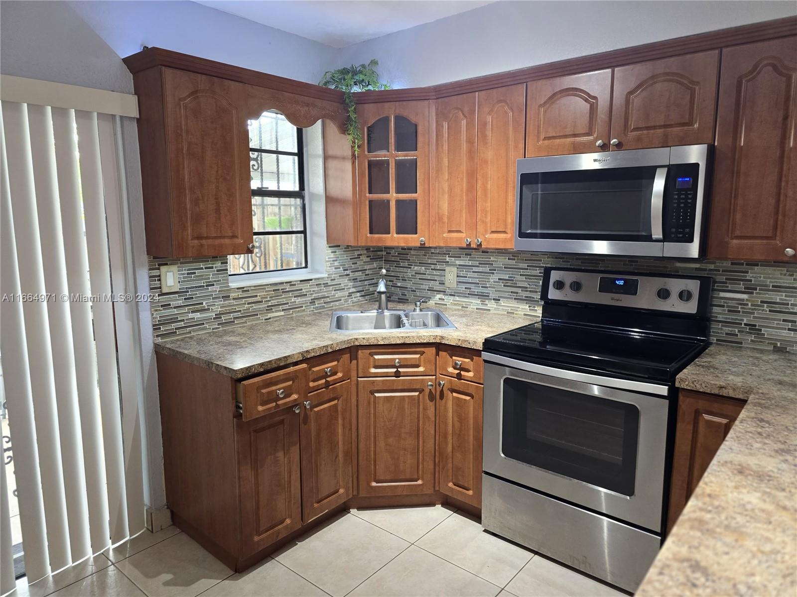 a kitchen with stainless steel appliances granite countertop a stove microwave and sink