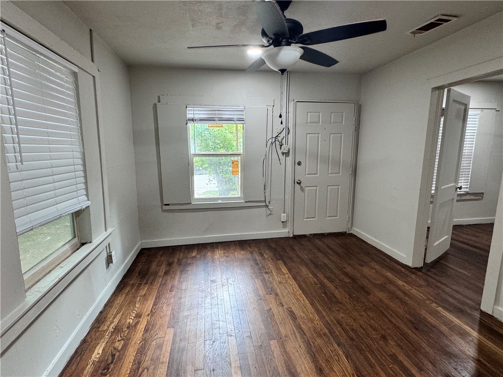 a view of an empty room window and wooden floor