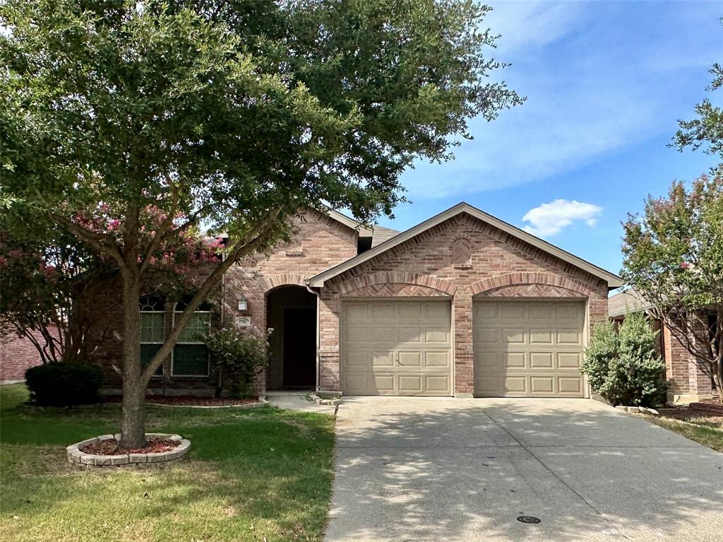 a front view of a house with a yard garage and trees