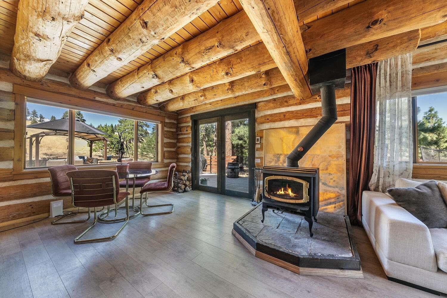 a living room with furniture a fireplace and large windows