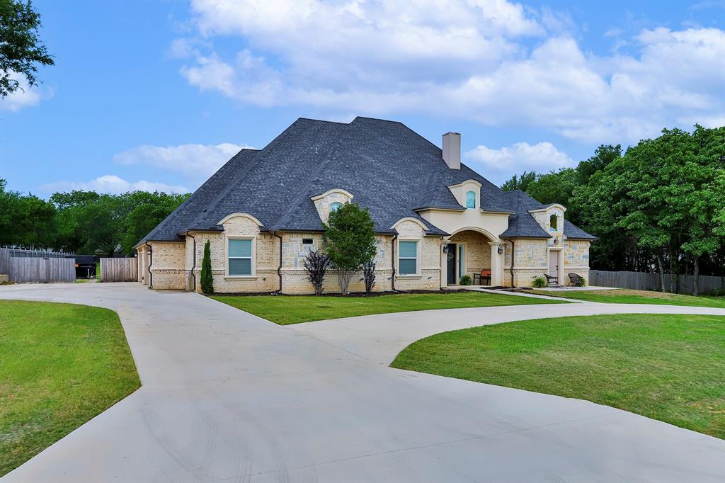 a front view of a house with a yard and trees