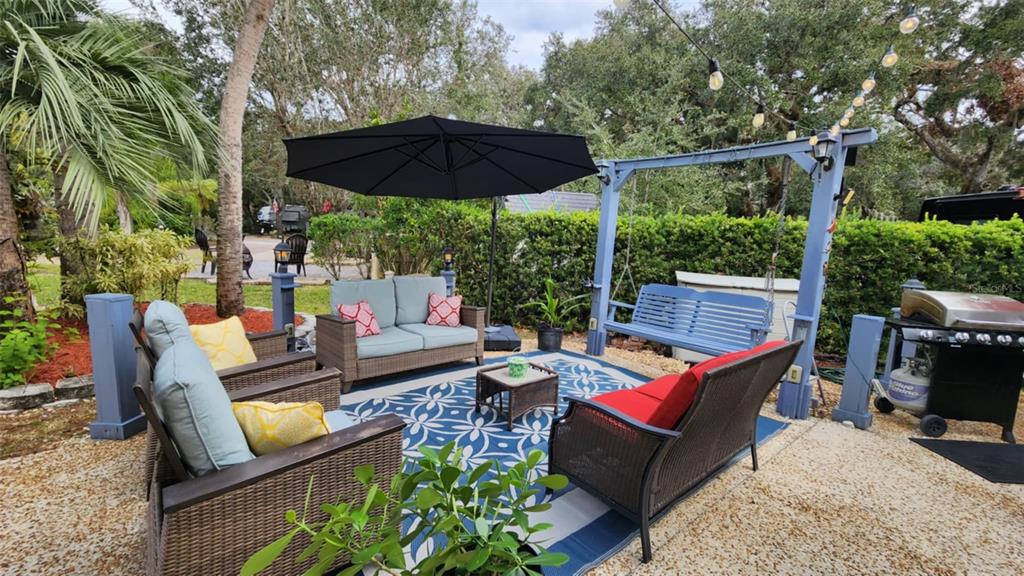 a backyard of a house with barbeque oven table and chairs