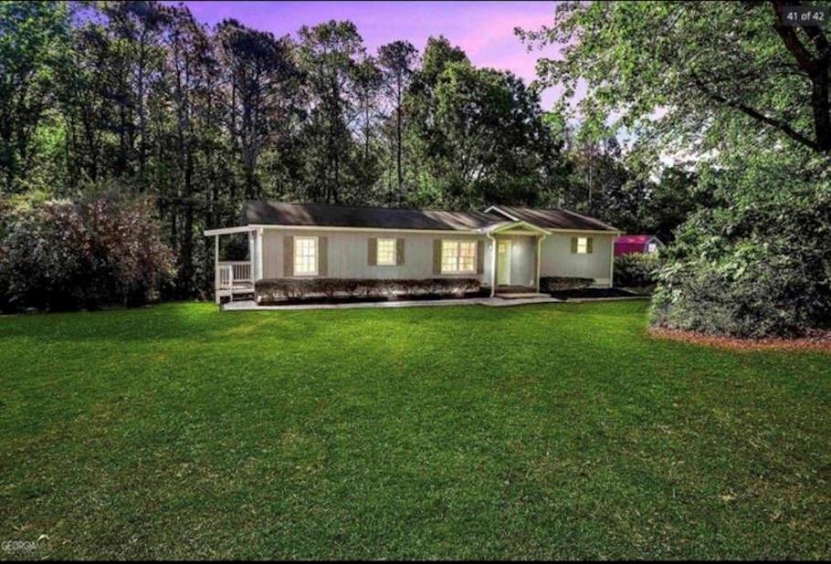 a front view of a house with a yard and trees