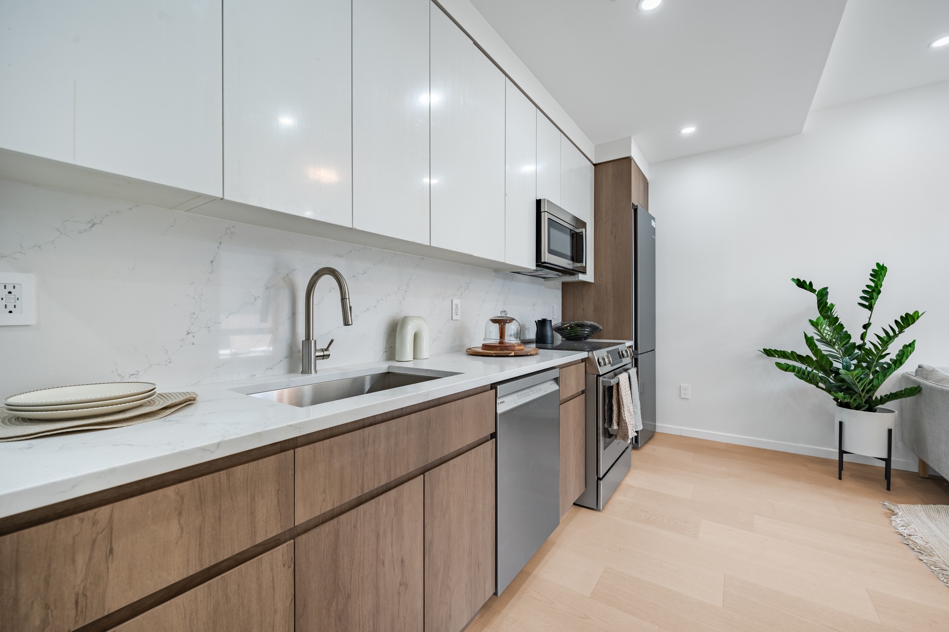 a kitchen with stainless steel appliances a sink a refrigerator and a white cabinets