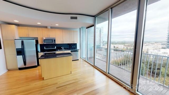 a kitchen with stainless steel appliances granite countertop a refrigerator and a stove top oven