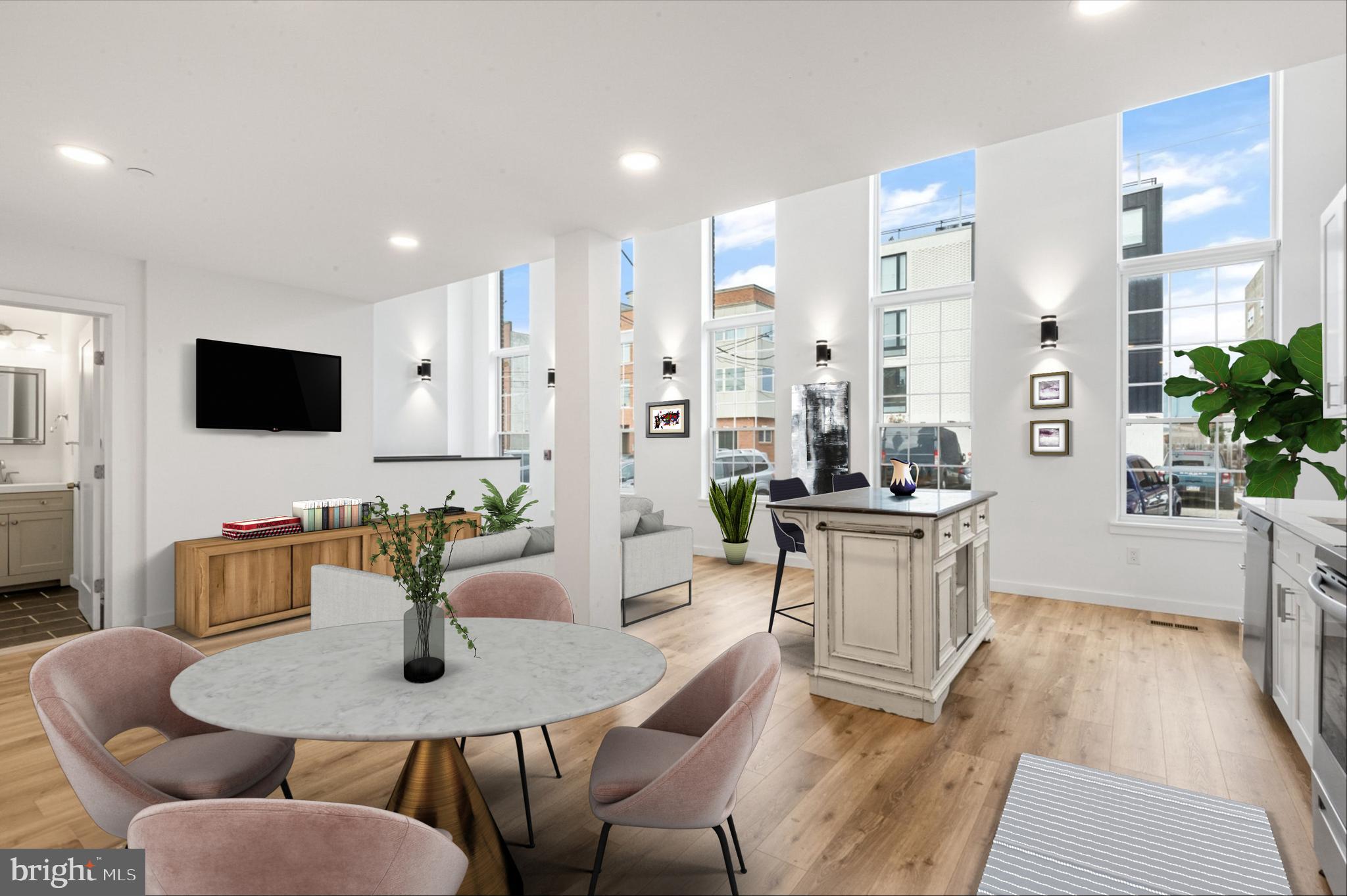 a living room with furniture a flat screen tv and kitchen area