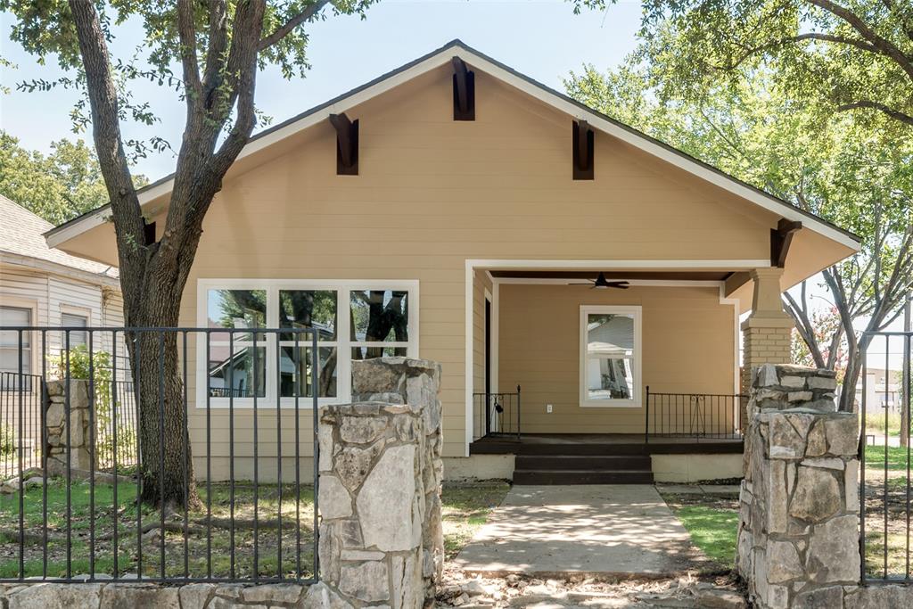 a front view of a house with a tree