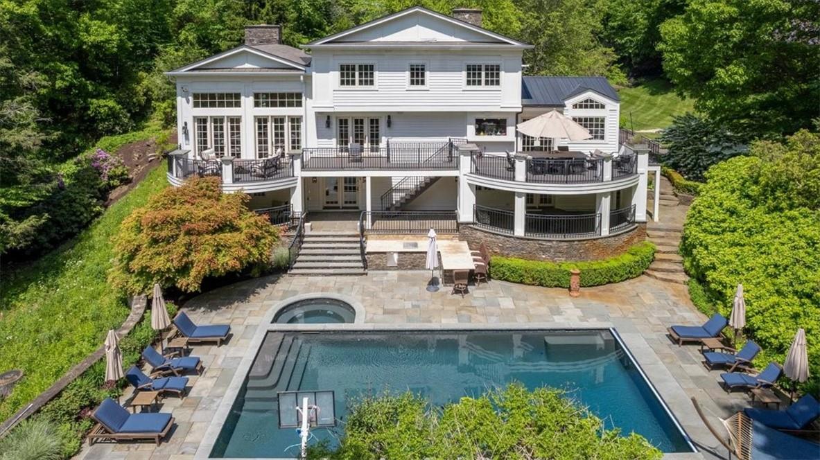 Rear view of property with a patio area, a balcony, and a pool with hot tub