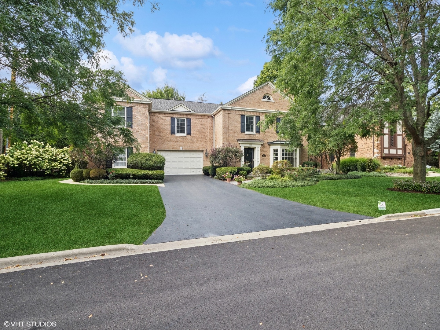 a front view of a house with a yard and trees