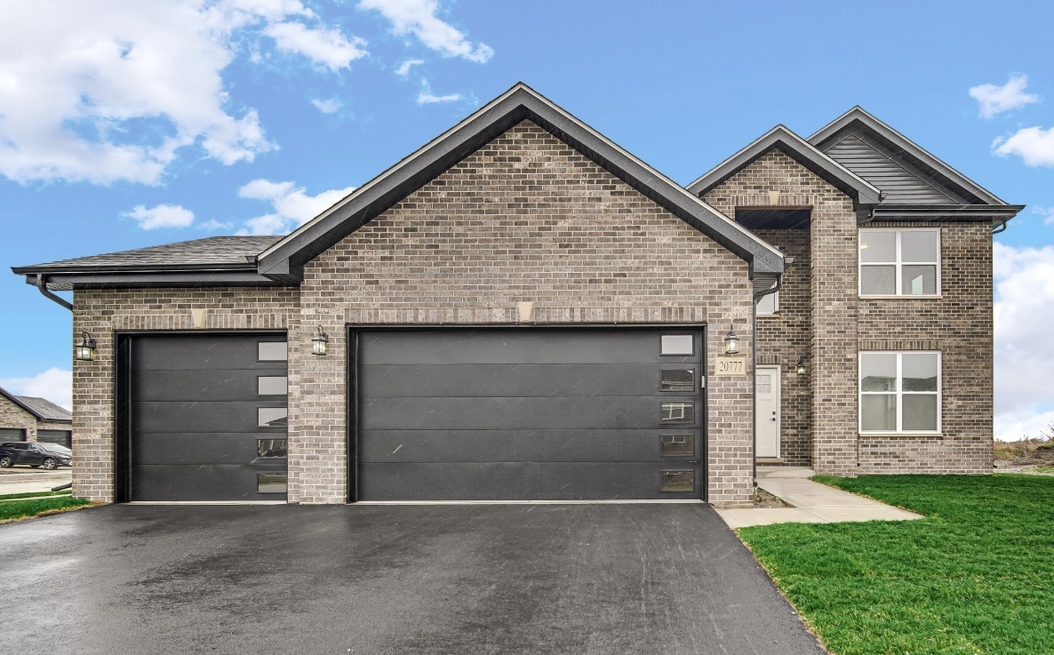 a front view of a house with a yard and garage