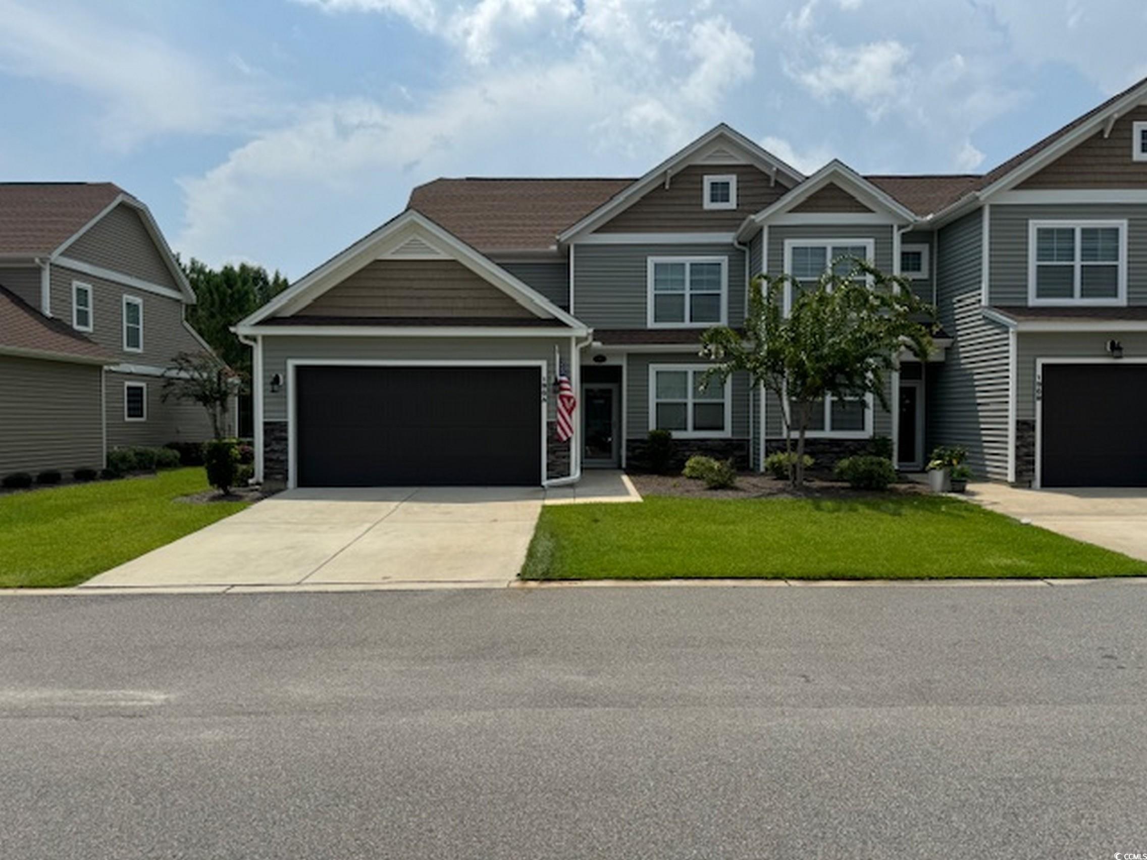 Craftsman house with a garage and a front lawn