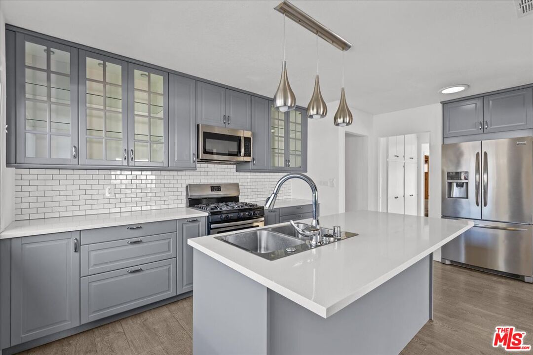 a kitchen with stainless steel appliances a sink a stove and a refrigerator