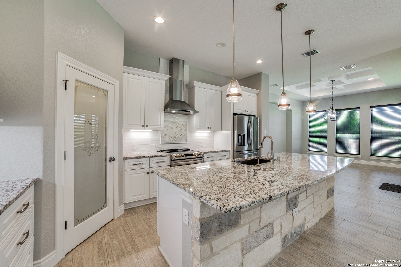 a kitchen with stainless steel appliances granite countertop a sink a stove and a refrigerator