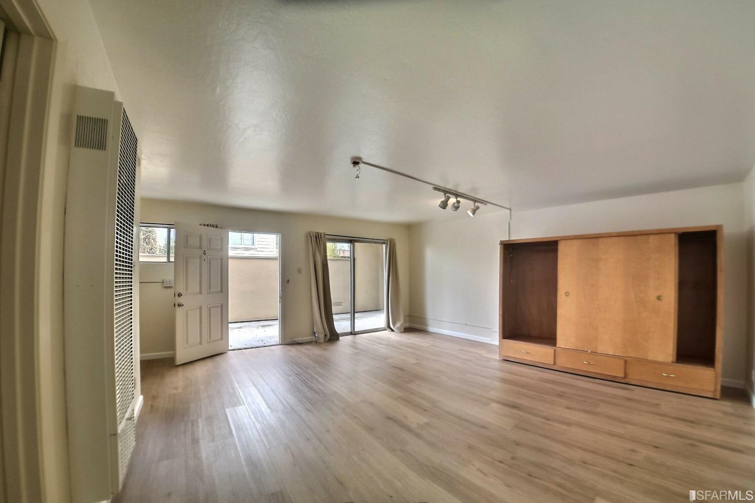 a view of a big room with wooden floor and windows