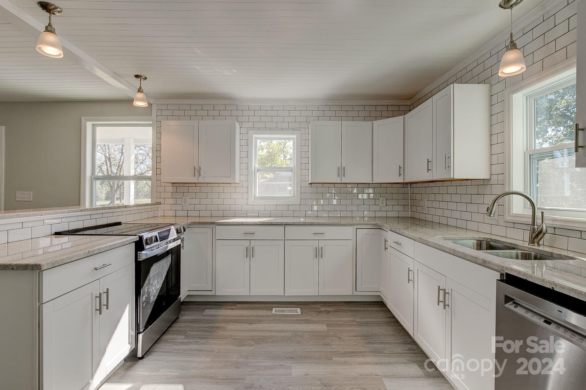 a kitchen with granite countertop cabinets stainless steel appliances a sink and a window