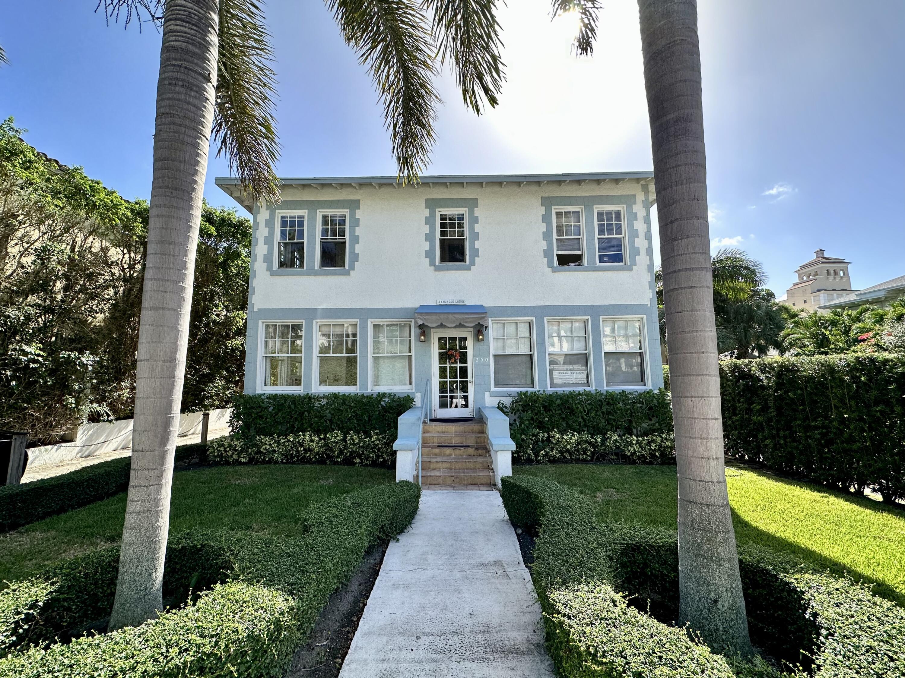 front view of house with a yard and potted plants