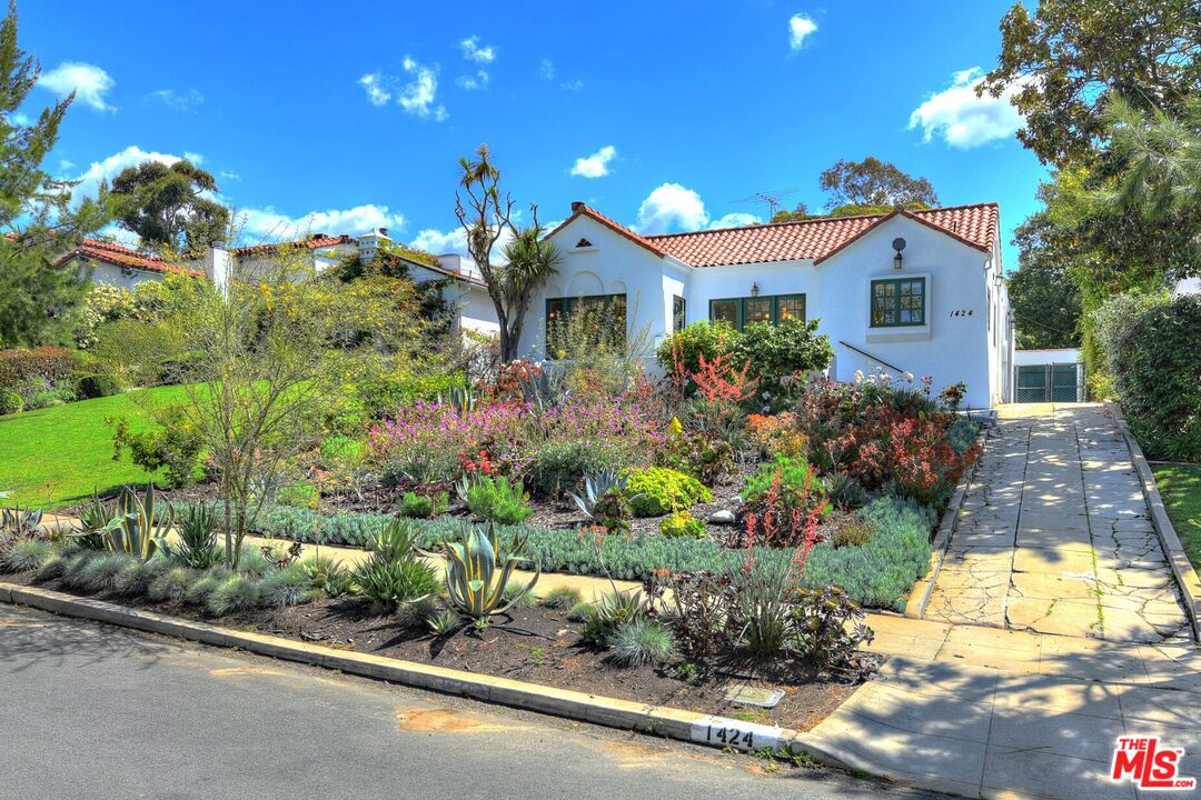 a front view of a house with a yard and fountain