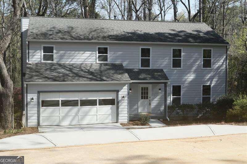 a front view of a house with a garden and garage