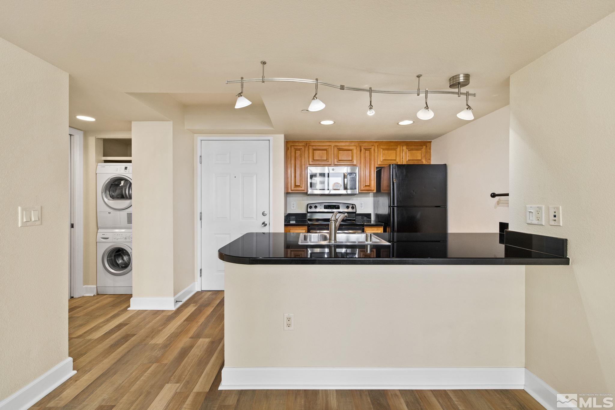 a kitchen with stainless steel appliances kitchen island a sink a refrigerator and a stove