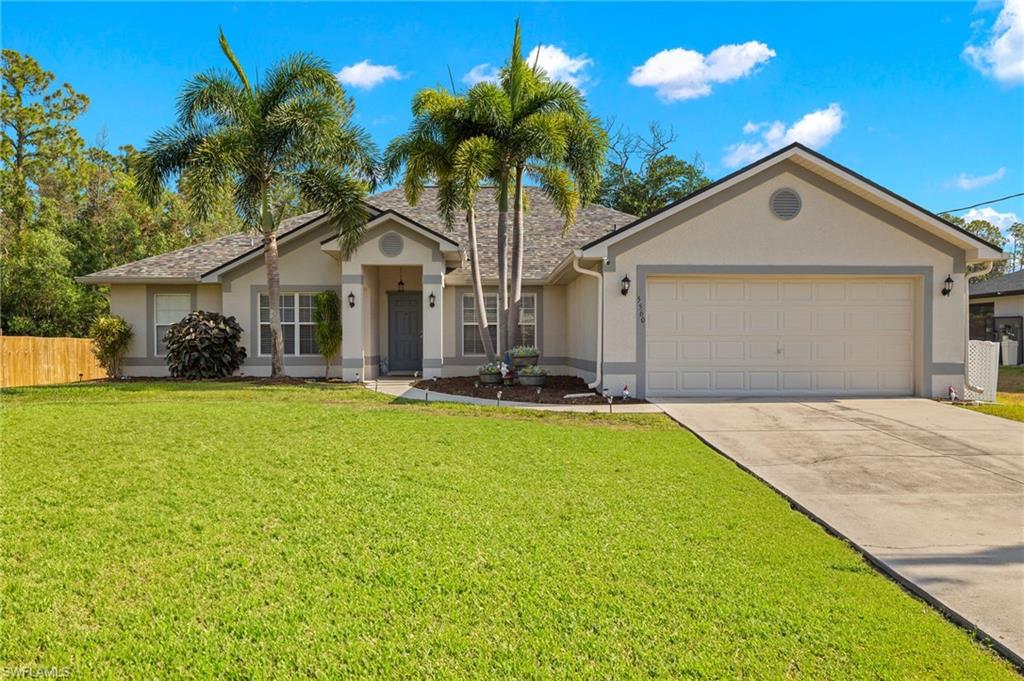 Ranch-style house with a garage and a front lawn