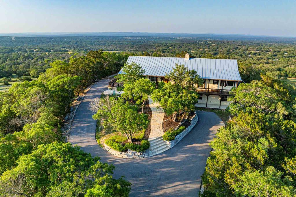 an aerial view of a house with a yard and lake view