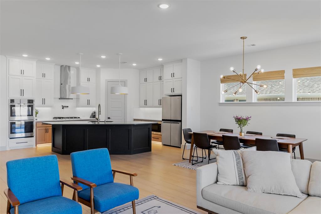 a living room with furniture kitchen view and a chandelier