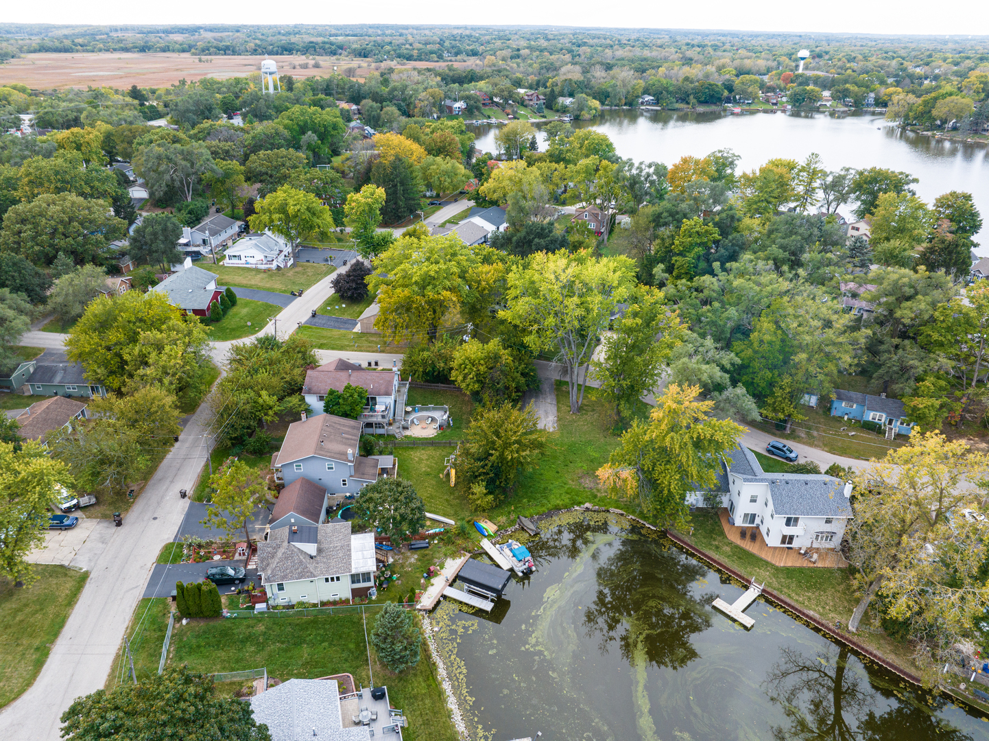 an aerial view of residential houses with outdoor space and lake view