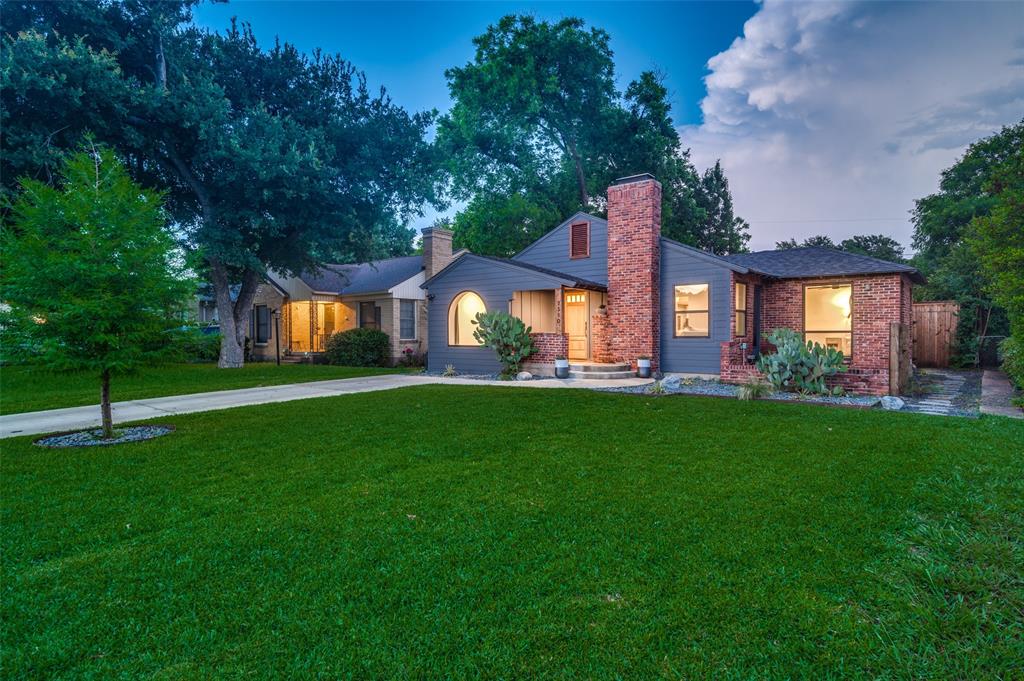 a front view of a house with a yard and green space