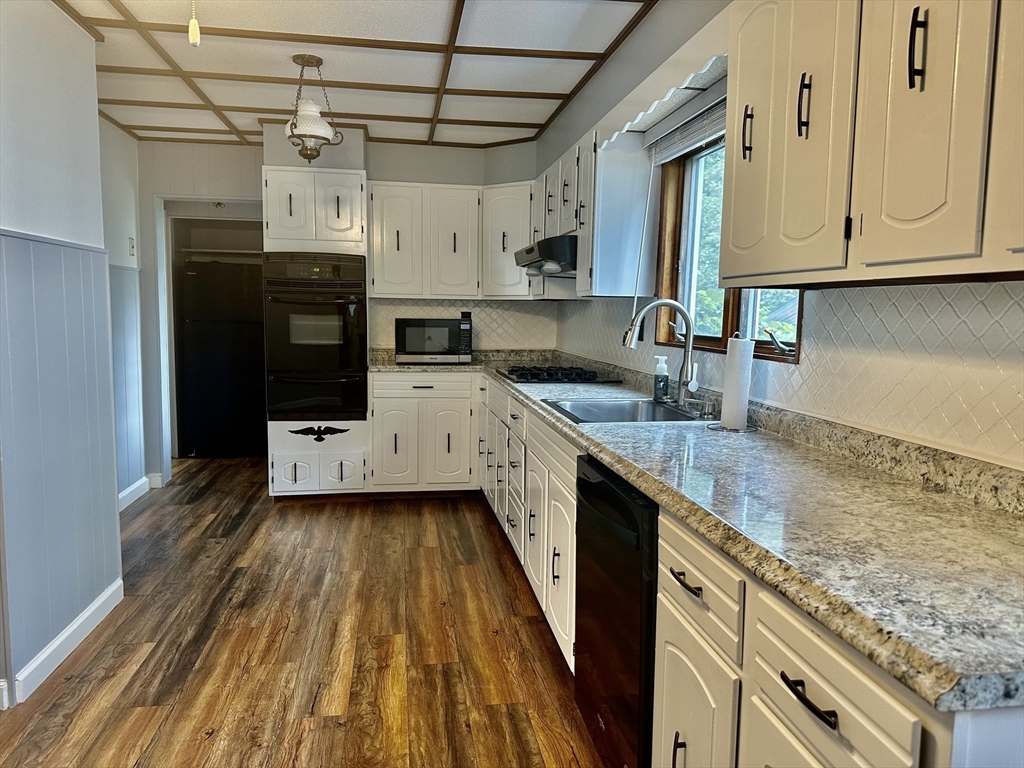 a kitchen with stainless steel appliances granite countertop a sink a stove and cabinets