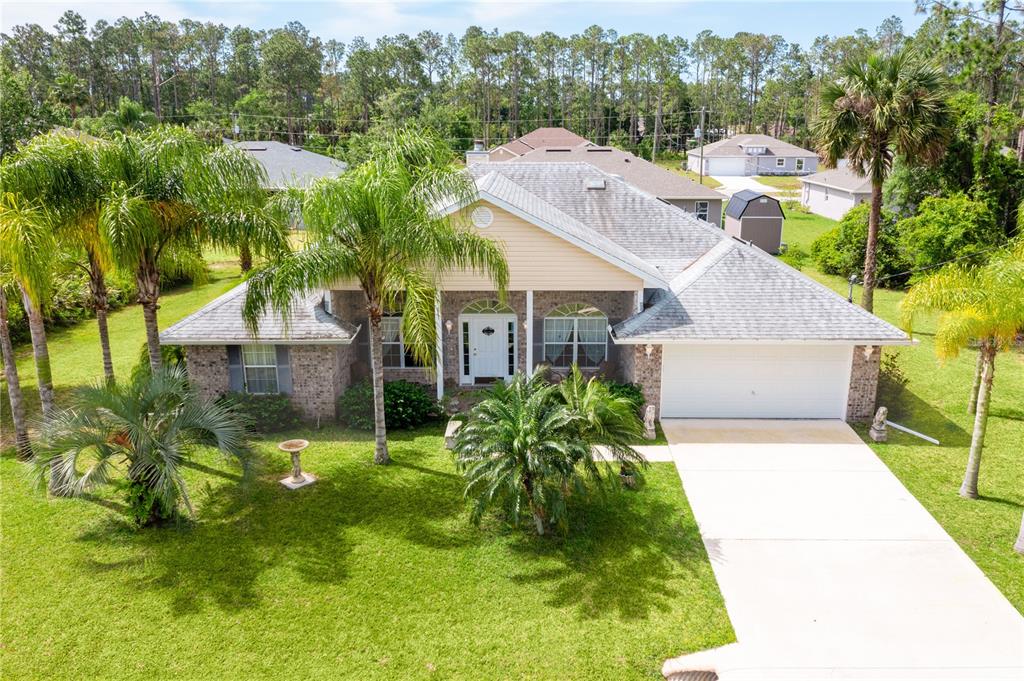 a aerial view of a house with a yard table and chairs