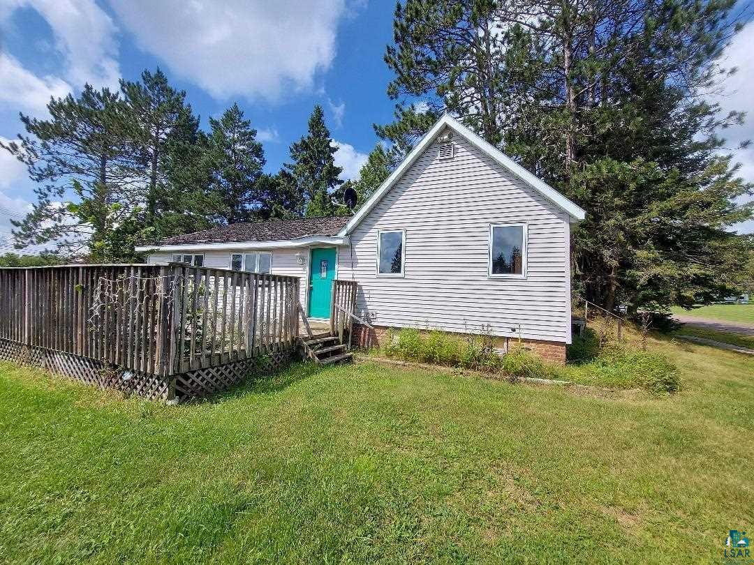 Back of property with a lawn and a deck