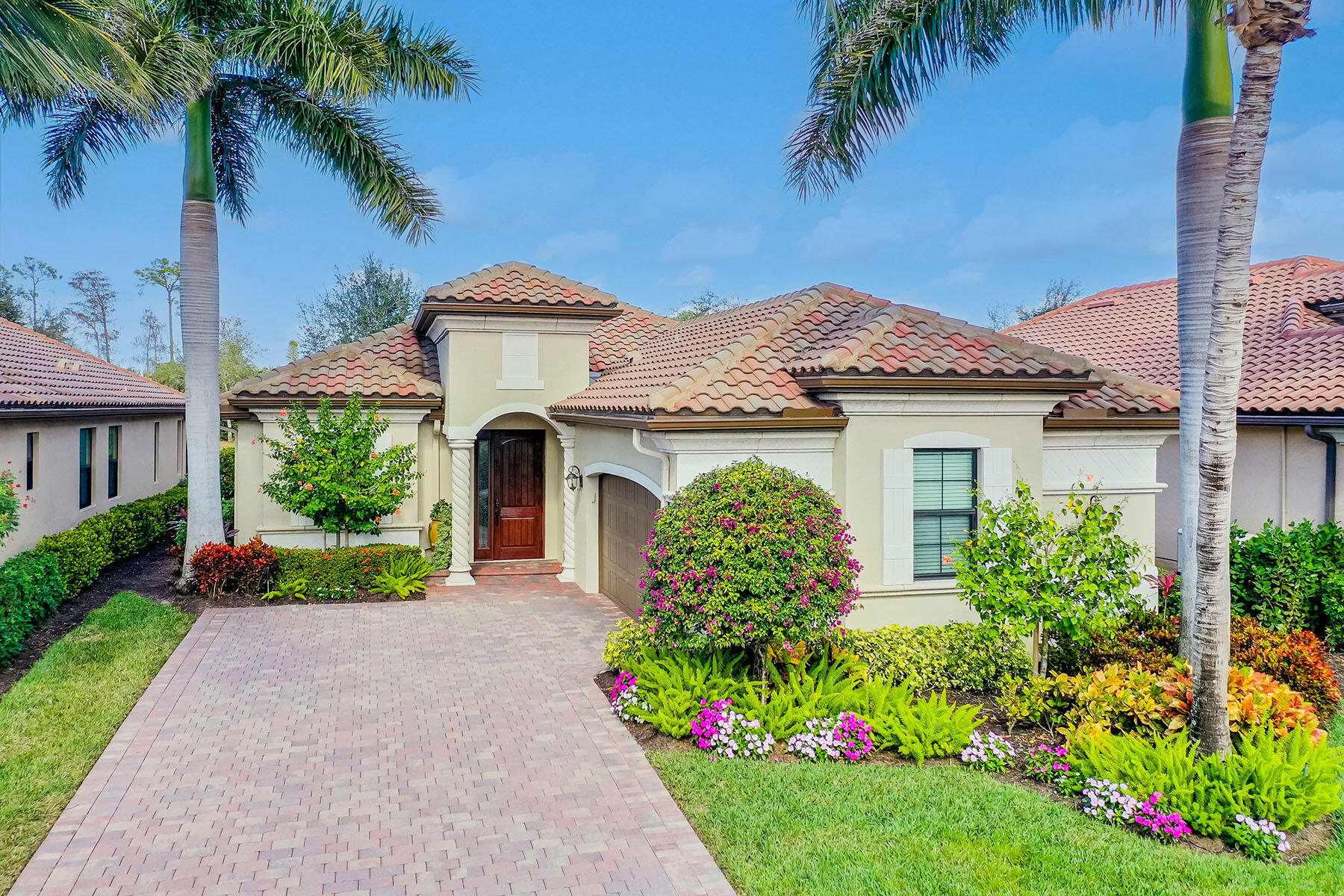 a front view of a house with a yard and potted plants