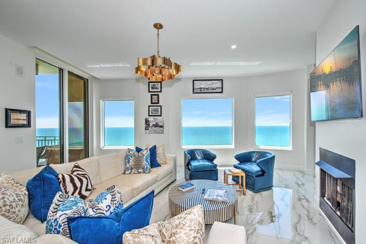 a living room with furniture chandelier and a fireplace