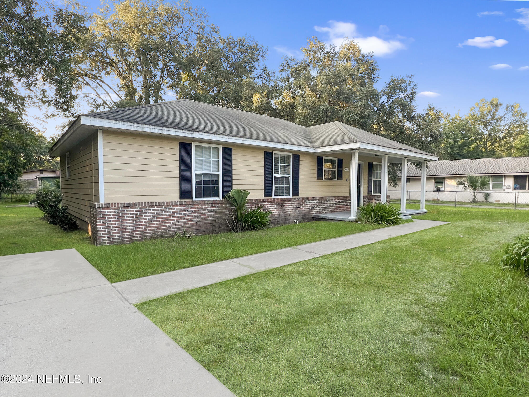 a front view of a house with a garden and yard