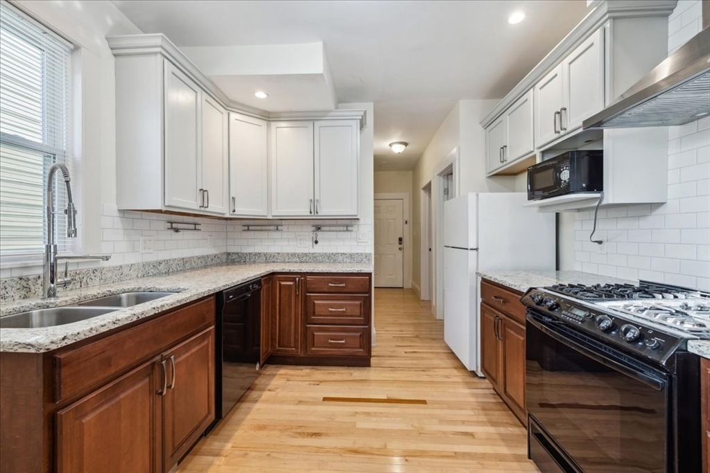 a kitchen with stainless steel appliances granite countertop a stove sink microwave and cabinets