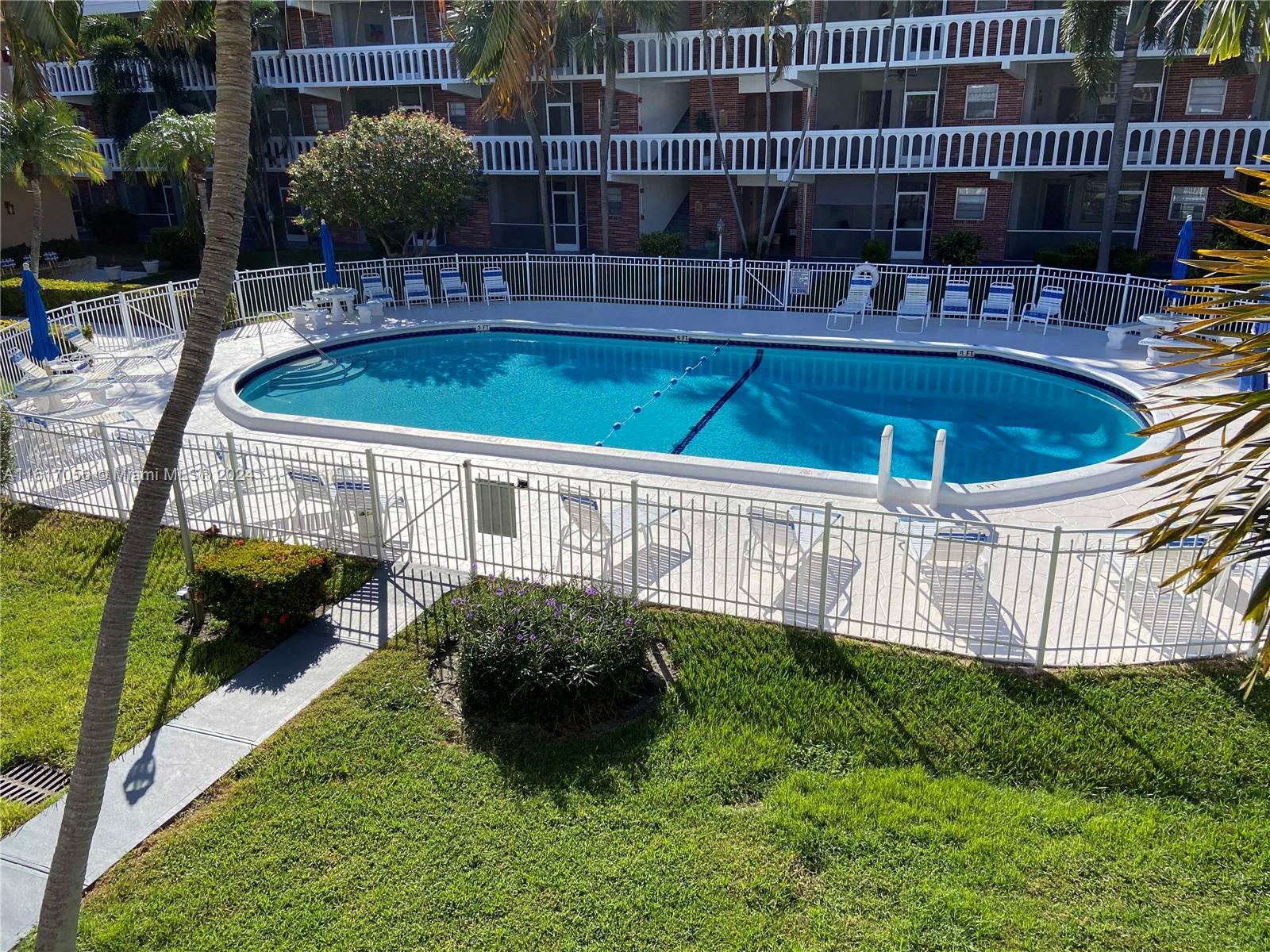 a view of a backyard with sitting area and swimming pool