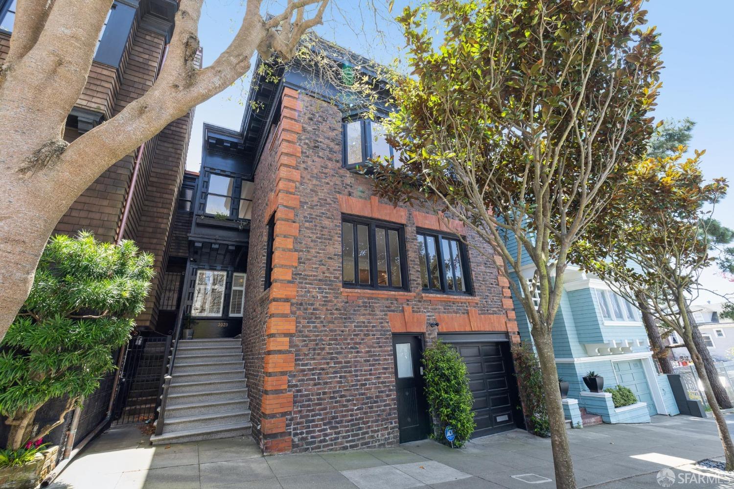 a front view of a house with a tree