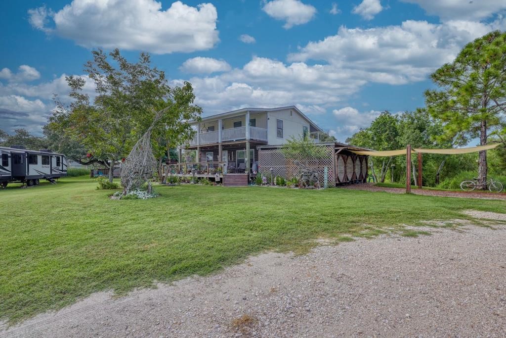 a view of a house with a big yard and large trees