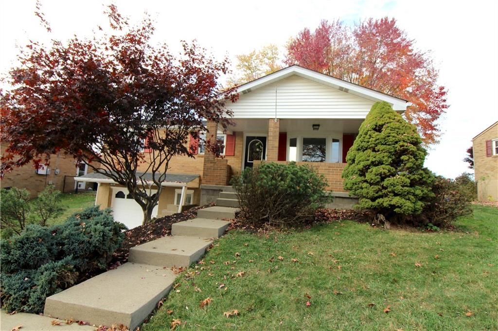 a front view of a house with a yard and trees