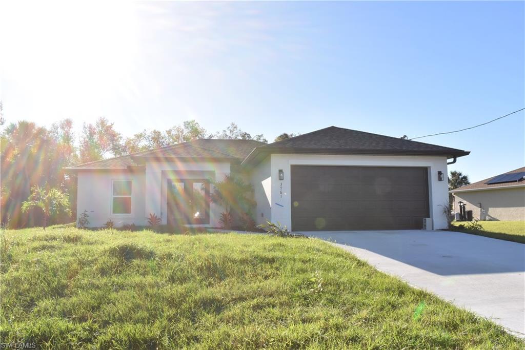 View of front facade featuring a garage and a front yard