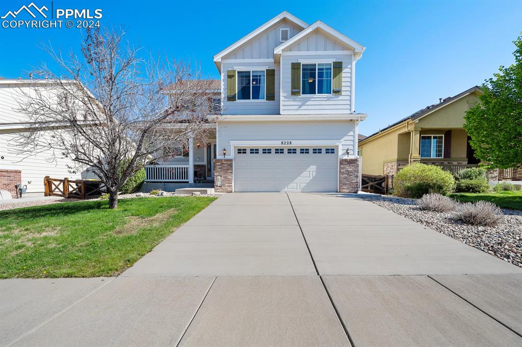 View of front of home featuring a front yard and a garage