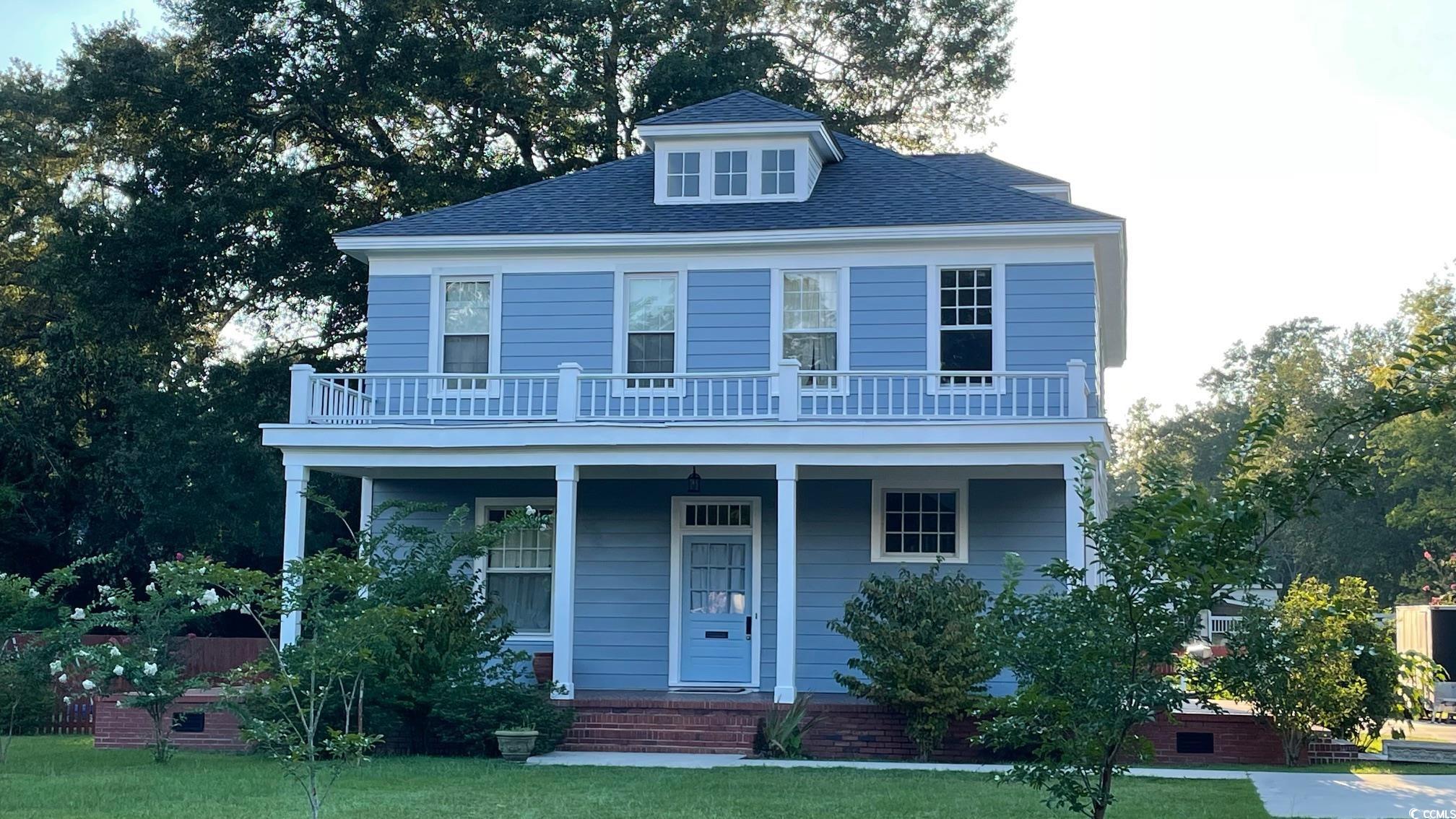 View of front of home featuring a balcony, a front