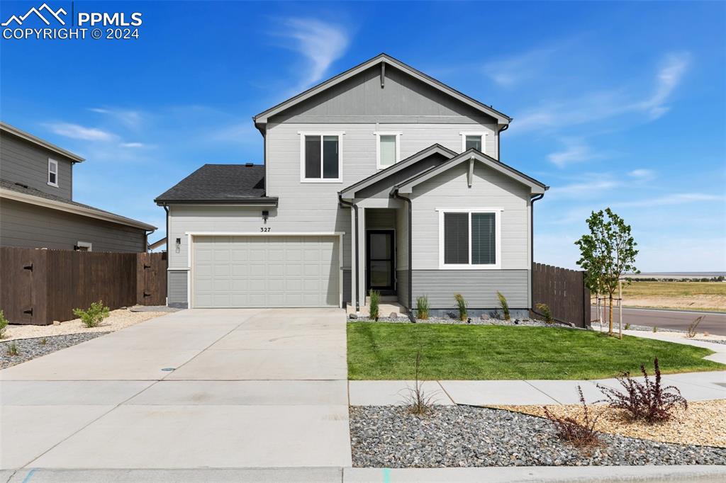 a front view of a house with a yard and garage