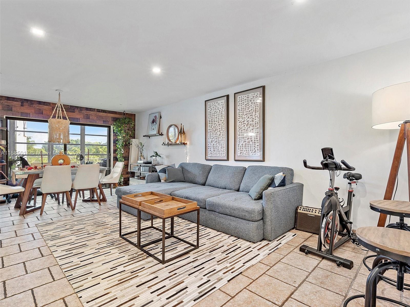 a living room with furniture a flat screen tv and a table