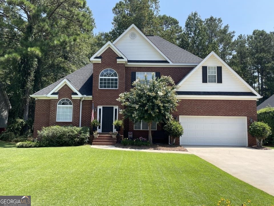 a front view of a house with a yard and garage