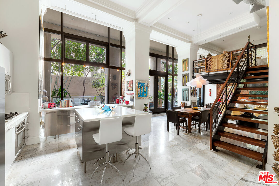 a view of a dining room with furniture staircase and a large window