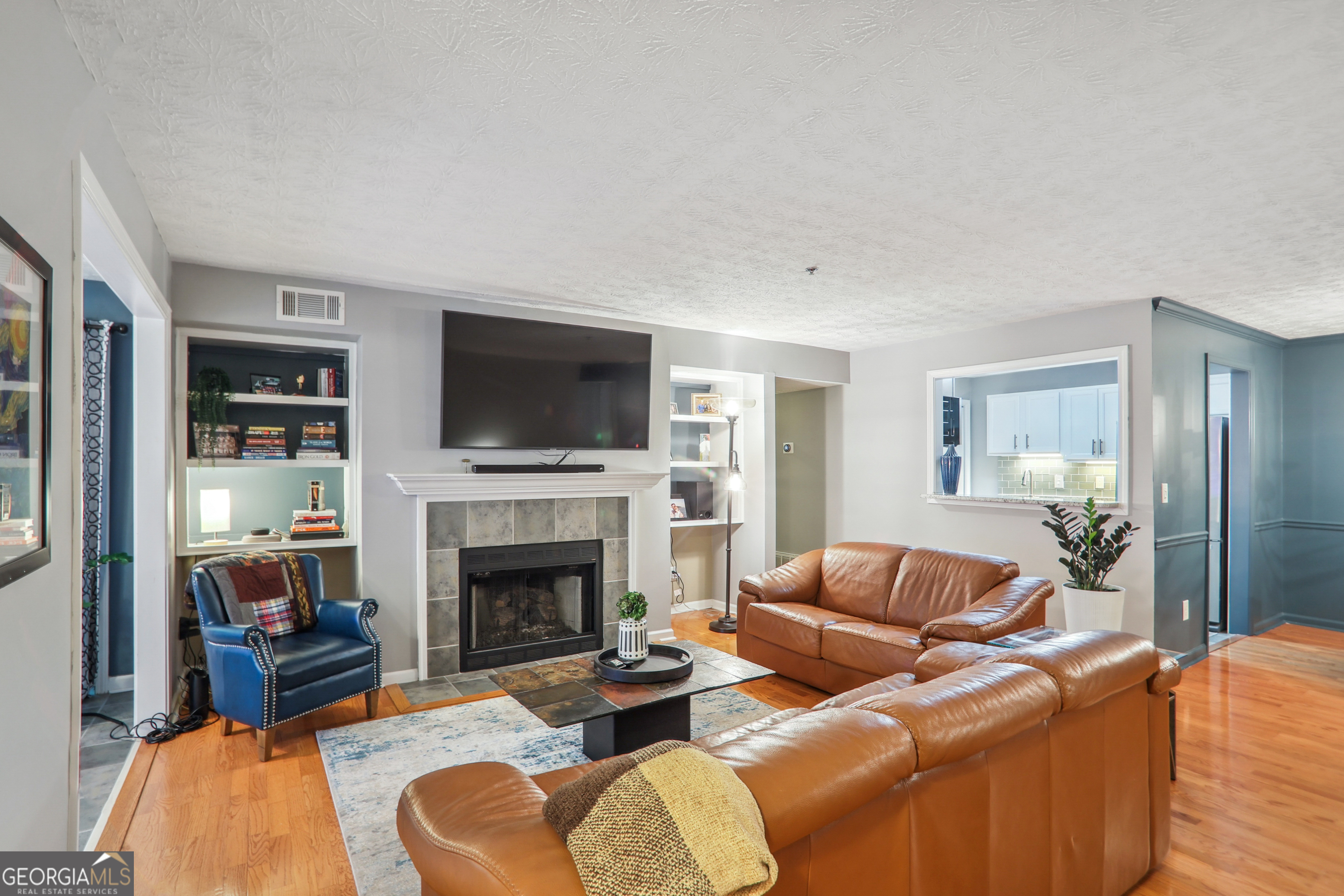 a living room with furniture a fireplace and a flat screen tv