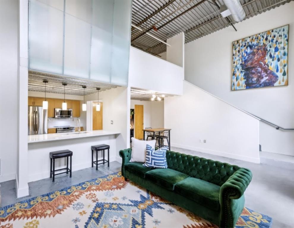 a living room with furniture a rug and white walls